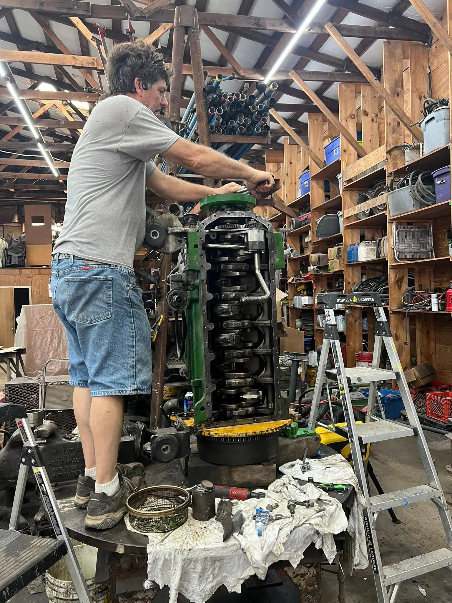 Inline-six engine rebuild in progress — crankshaft and rods on the stand